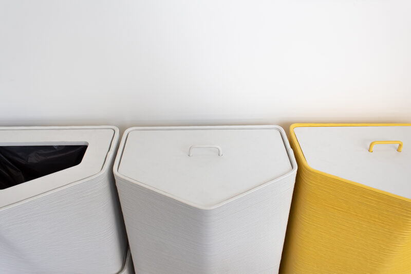 3D-printed sustainable waste system bin recycled plastic refrigerator white and iconic yellow close-up