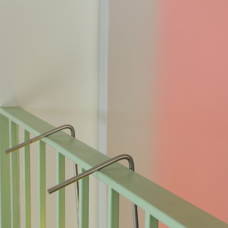 Poko sustainable lamp frame with dimmable light, hanging from a banister